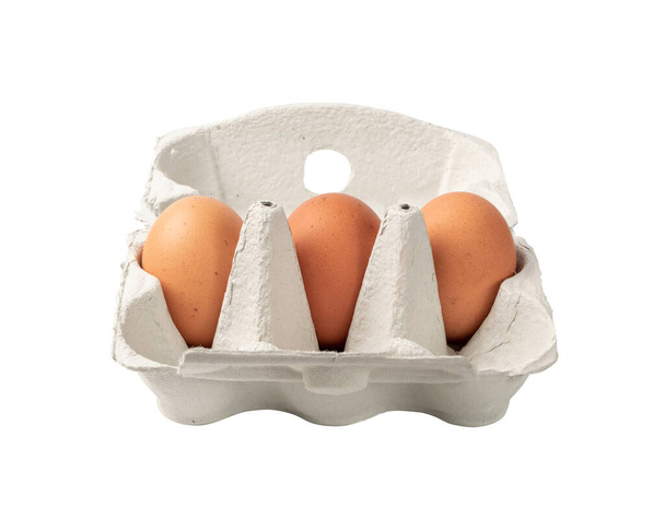 Caixa aberta com três ovos marrons inteiros isolados em fundo branco com caminho de recorte. Ovos de galinha orgânicos frescos em embalagem de cartão ou recipiente de ovo
 - Foto, Imagem