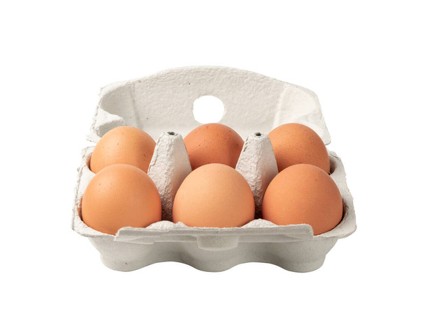 Caixa aberta com seis ovos marrons inteiros isolados em fundo branco com caminho de recorte. Ovos de galinha orgânicos frescos em embalagem de cartão ou recipiente de ovo
 - Foto, Imagem