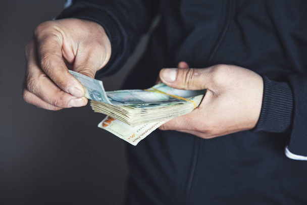 man hand holding money on gray abckground - Foto, Imagen