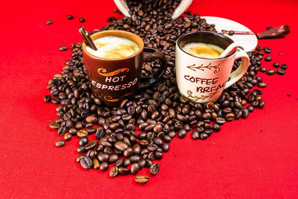 Taza de café, granos de café tostados sobre fondo rojo, vista superior, espacio de copia para el texto, concepto de café, foto de café de cerca - Foto, imagen