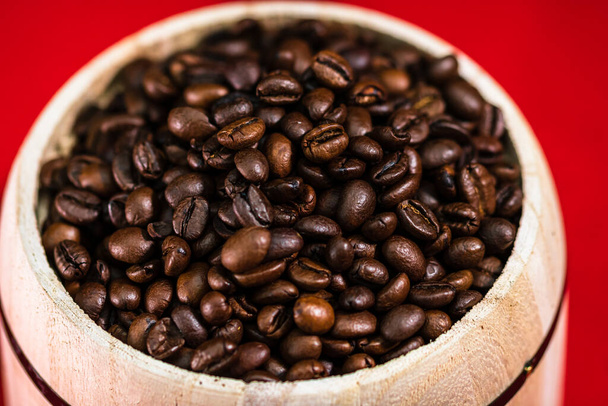 Grains de café torréfiés dans un pot de café en bois sur fond rouge, concept de café
 - Photo, image
