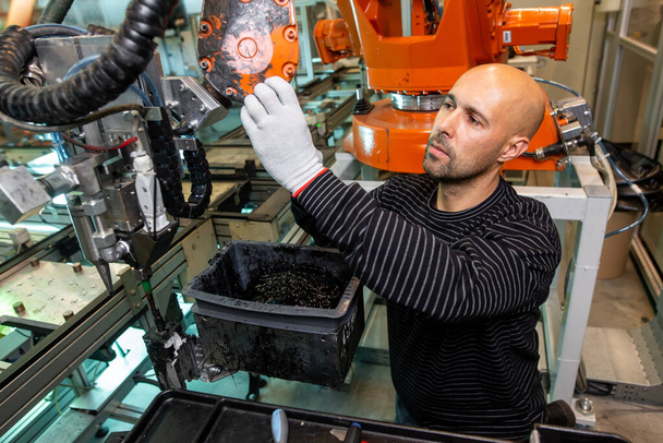 Engenheiro otimizando a produção por braço robótico na fábrica inteligente automotiva, empregado na indústria, conceito industrial
 - Foto, Imagem
