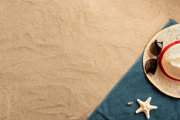 Hermoso fondo de playa de vacaciones de verano con sombrero de paja y conchas marinas sobre fondo de arena, diseño de borde, vista superior con espacio de copia
 - Foto, Imagen