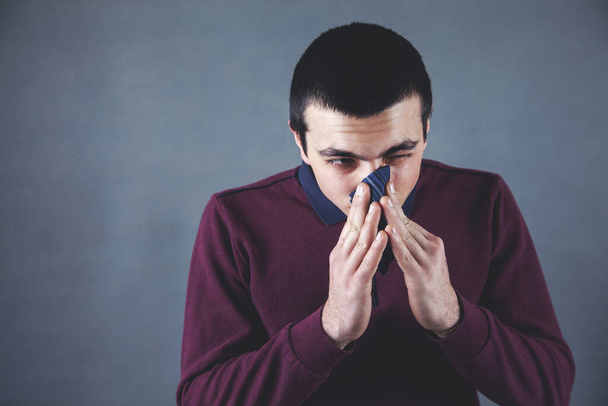 man clean the nose with a handkerchief on dark background - Zdjęcie, obraz