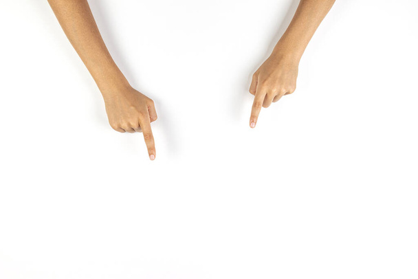 Manos de niño apuntando hacia abajo con los dedos a algo sobre fondo blanco
 - Foto, Imagen