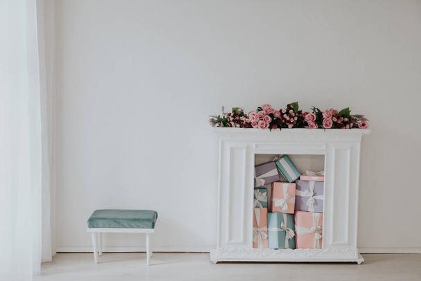 камін з квітами і подарунками в інтер'єрі білої кімнати
 - Фото, зображення