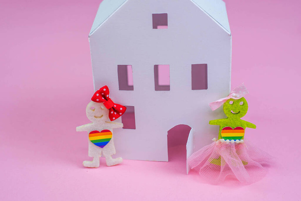 Liczby osób LGBT. Dwie postacie kobiet pokazują niekonwencjonalną orientację w pobliżu papierni. Małżeństwo i rodzina, para.Różowe tło. - Zdjęcie, obraz