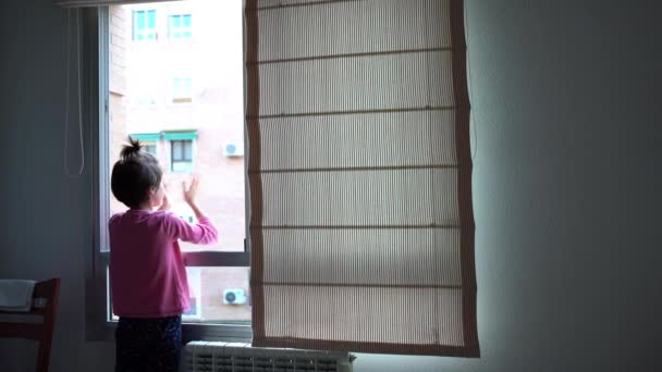 Κορίτσι χειροκροτεί στο παράθυρο για την υποστήριξη των ανθρώπων που αγωνίζονται κατά του coronavirus - Πλάνα, βίντεο