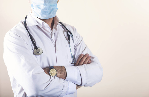 Zelfverzekerde arts poserend met gekruiste armen en stethoscoop - Foto, afbeelding