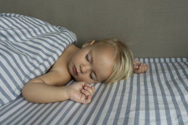 Cute baby sleeps well, raising hands up - Valokuva, kuva