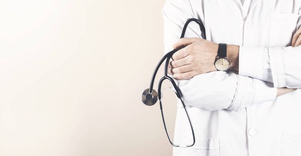 Pewny siebie lekarz pozujący z krzyżowanymi ramionami i stetoskopem - Zdjęcie, obraz