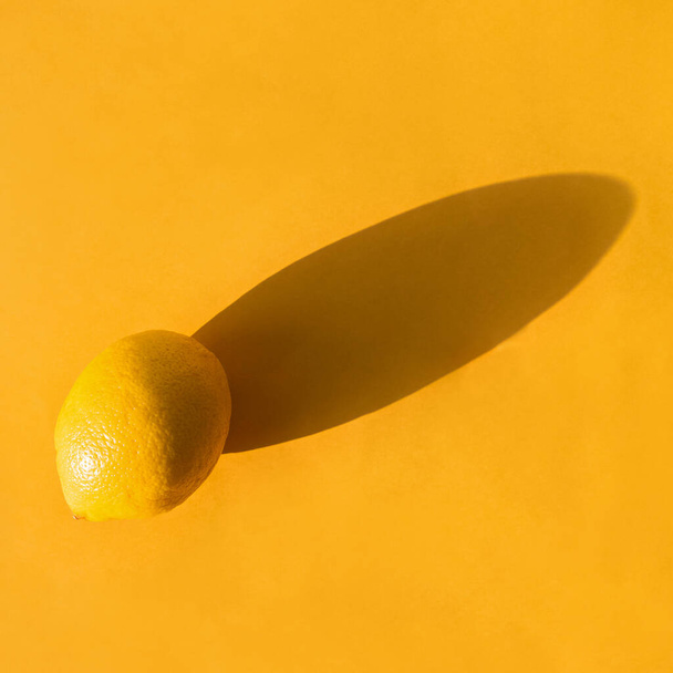 Whole lemon on a yellow paper background - Fotoğraf, Görsel