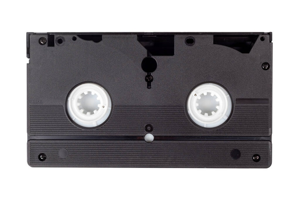 Beyaz, arka tarafta izole edilmiş tek bir eski siyah VHS video kaseti. Retro teknoloji, videolar, modası geçmiş video kasetler, 80 'lerden ve 90' lardan kalma teknolojik eşyalar. Beyaz üzerine bir video kaset, merkez yakın plan. - Fotoğraf, Görsel