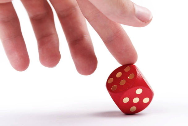 Helping your luck, cheating in games, dishonesty concept. A human finger pushing over a dice to make it show a six. Unfair ace in the sleeve, cheater, uneven odds in business concept - Photo, Image