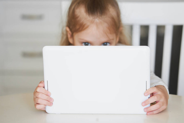 Online Education concept. Little child girl using laptop for distance learning at home - Foto, afbeelding
