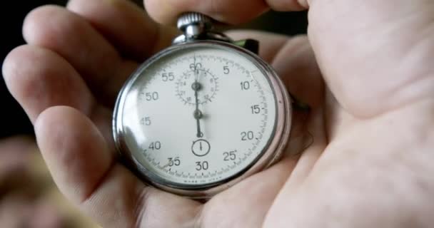 Una persona poniendo en marcha un cronómetro en negro
 - Metraje, vídeo