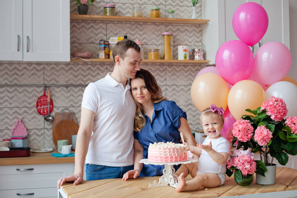 family on the table with a birthday cake and balloons - Foto, afbeelding
