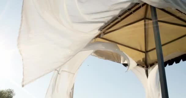 Fedett kerti ház a tengerparton. Homokos part. A függöny a szélben fejlődik.. - Felvétel, videó