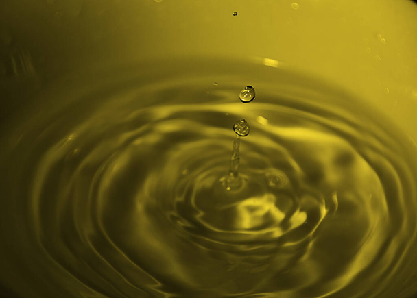 Gota de agua en tazón blanco, tonos amarillos, azulado, olas
, - Foto, Imagen
