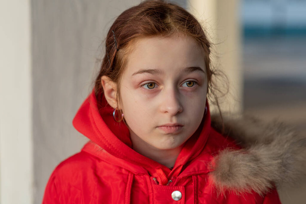 Közelkép egy gyönyörű 9 éves kislányról. Iskolás gyerek téli ruhában. 9 éves lány. Tinédzser, portré. Egy piros kabátos lány. Új generáció. a Z-generáció gyermekei - Fotó, kép