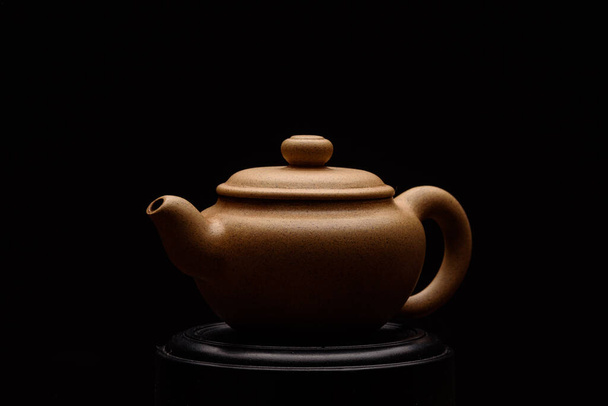 Clay Chinese teapot on a black background - Fotoğraf, Görsel