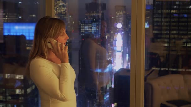 閉じる:タイムズスクエアを見ながら電話で話している若いビジネスマンの女性. - 映像、動画