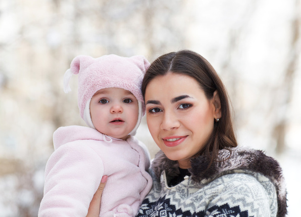 Young brunette mother with her daughter outdoors. Winter - Photo, Image