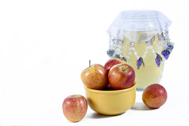 натуральные и здоровые яблоки тропические фрукты внутри желтого горшка изолированы на скамейке фоне
 - Фото, изображение
