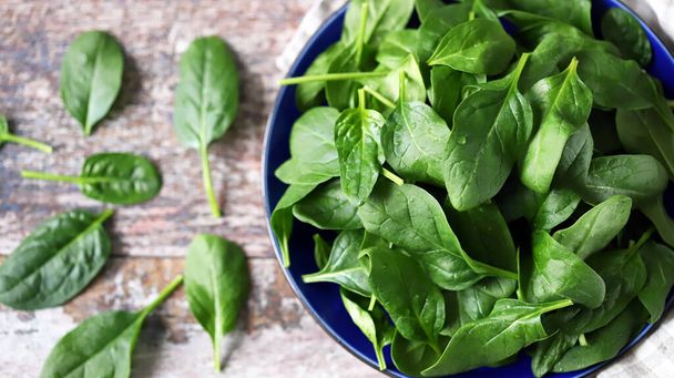 Fresh baby spinach on a plate. Juicy spinach leaves. Diet concept. Vegan food. - Photo, Image
