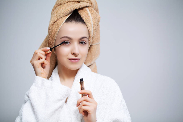 Linda mujer en el baño haciendo procedimiento cosmético para el cuidado de la piel facial
 - Foto, imagen
