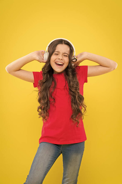 Kid listening music headphones. Music beat concept. Entertainment and fun. Top summer songs. Child or teen enjoy music playing in earphones. Little girl enjoying her favorite music. Catch the rhythm - 写真・画像