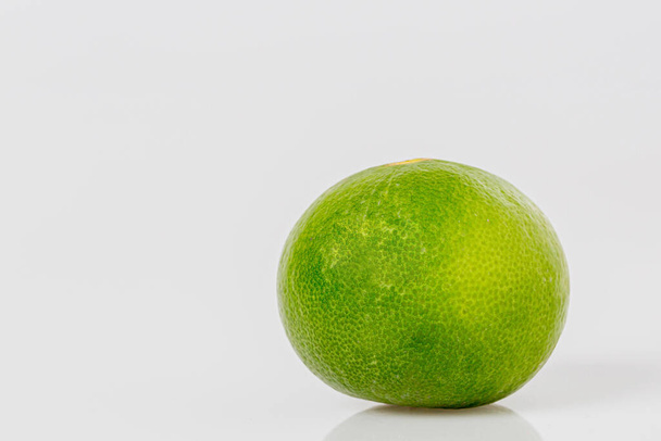 Fresh lime isolated on white background. Fresh green lime A black shadow on a white background.  - Foto, afbeelding