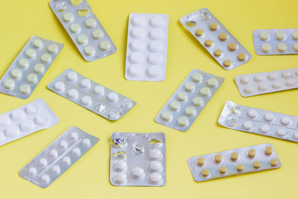 Embalaje de ampollas con pastillas sobre un fondo amarillo
 - Foto, imagen