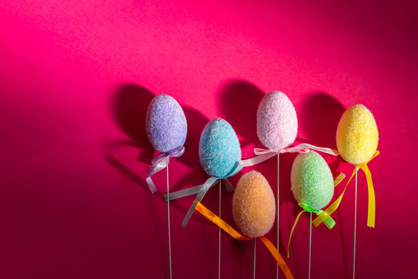 Fluffy colorful plastic eggs isolated on red background. Easter concept. Space for text - Fotoğraf, Görsel