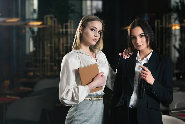 Tópico de negócios e discurso: duas mulheres em pé juntas
 - Foto, Imagem