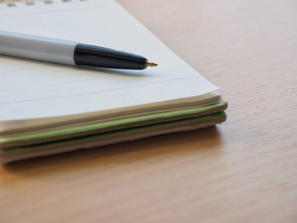 White notebook and black ballpoint pen - Фото, зображення