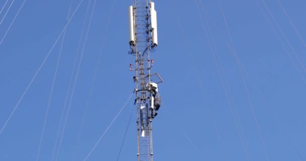 Zbliżenie zdjęć lotniczych wokół wieży telekomunikacyjnej w wiejskiej lokalizacji. Anteny wieży telekomunikacyjnej i satelita przesyła sygnały komórkowe 5g 4g sygnałów komórkowych do konsumentów i smartfonów. - Materiał filmowy, wideo