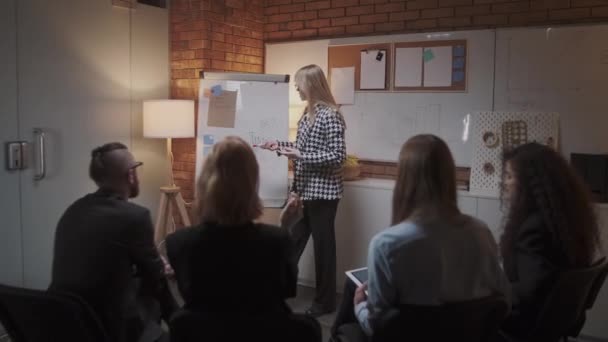 女性マネージャーは会議で同僚に新しいプロジェクト計画を提示し、オフィスの同僚にアイデアを説明し、ビジネスウーマンはプレゼンテーションを行います - 映像、動画