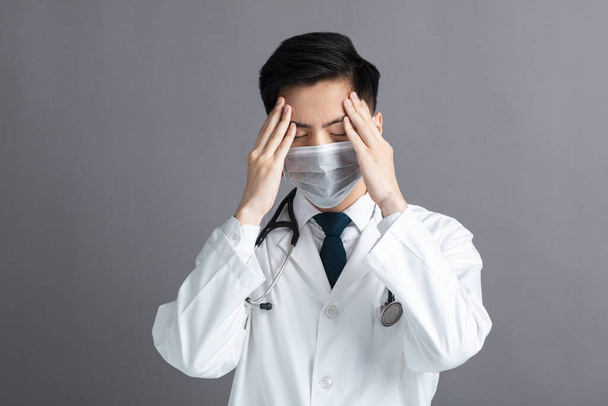 stressz és fáradt fiatal Doktor viselni orvosi maszk - Fotó, kép