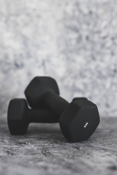 sport and fitness gear, set of black dumbbells on concrete shot at shallow depth of field - Photo, Image