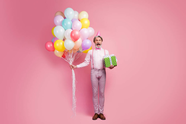 Full length body size view of nice attractive well-dressed elegant glad cheerful grey-haired man holding in hands bunch air balls giftbox delivery isolated over pink pastel color background - Valokuva, kuva