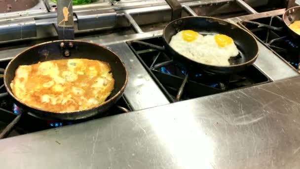 Cocinar tortillas y huevos fritos. Desayuno buffet en el restaurante del hotel. 4K
 - Imágenes, Vídeo