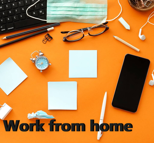 Stay home, work from home message. Coronavirus Covid -19 quarantine concept.  Office desk top view  on orange background.Copy space. - Foto, imagen