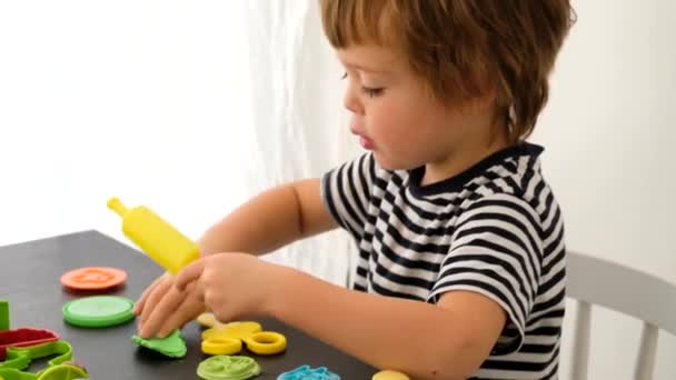 カラフルなモデリング粘土で遊ぶ男の子 - 映像、動画