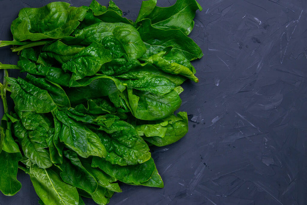 Freshly picked spinach on the black slate board, top view, Space for text Background for a recipe. - Foto, Bild