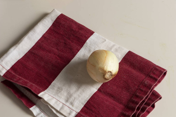 Cebolla blanca en trapo rojo lista para preparar comida casera - Foto, immagini