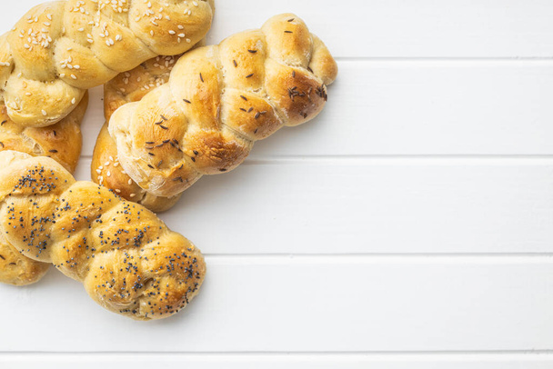 Tasty braided buns on white table. Top view. - Foto, imagen