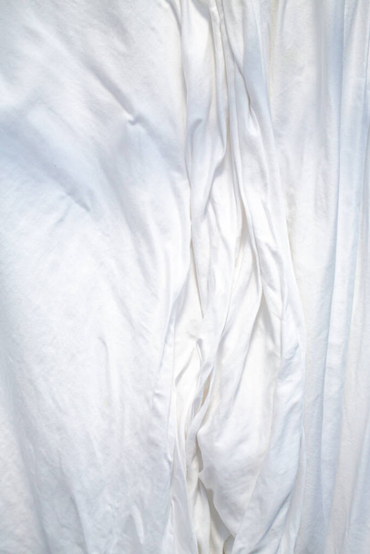 Λευκό σεντόνι ξήρανση στον ήλιο, ρυτιδωμένη υφή, Αφηρημένο φόντο, Κοντινό πλάνο, επιλεκτική εστίαση, Οικιακές εργασίες, Πλυντήριο ρούχων έννοια - Φωτογραφία, εικόνα