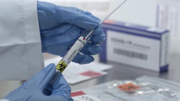Coronavirus swab test being sealed in vile and plastic bag in lab viewing covide-19 test kit. - Filmati, video