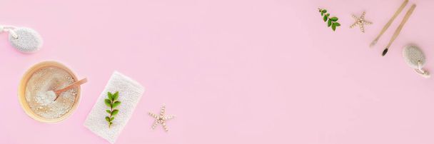 衛生とボディケアのためのフラットレイアクセサリー:ピンクの背景に軽石、木製の歯ブラシ、化粧土や綿タオル。トップビュー、フラットレイアウト、コピースペース. - 写真・画像